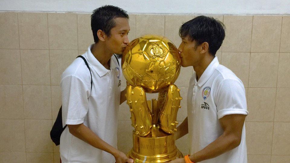 Dua pemain Arema FC, Arif Suyono (kiri) dan Ahmad Bustomi cium trofi trofeo Bhayangkara 2017. - INDOSPORT
